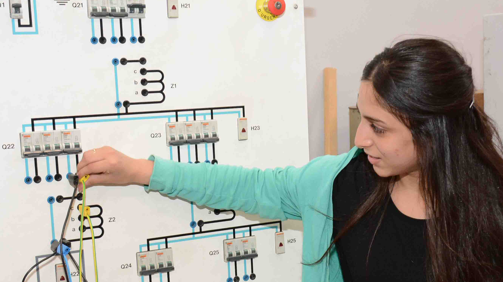 Young woman learning electricity at board