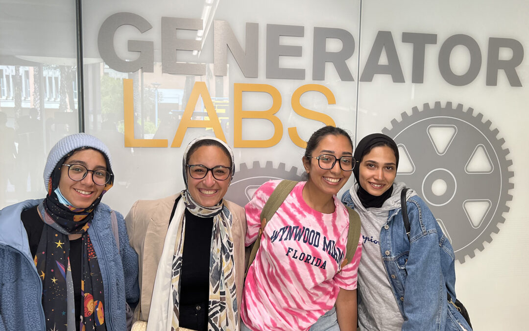 Four female students stand in front of laboratory sign