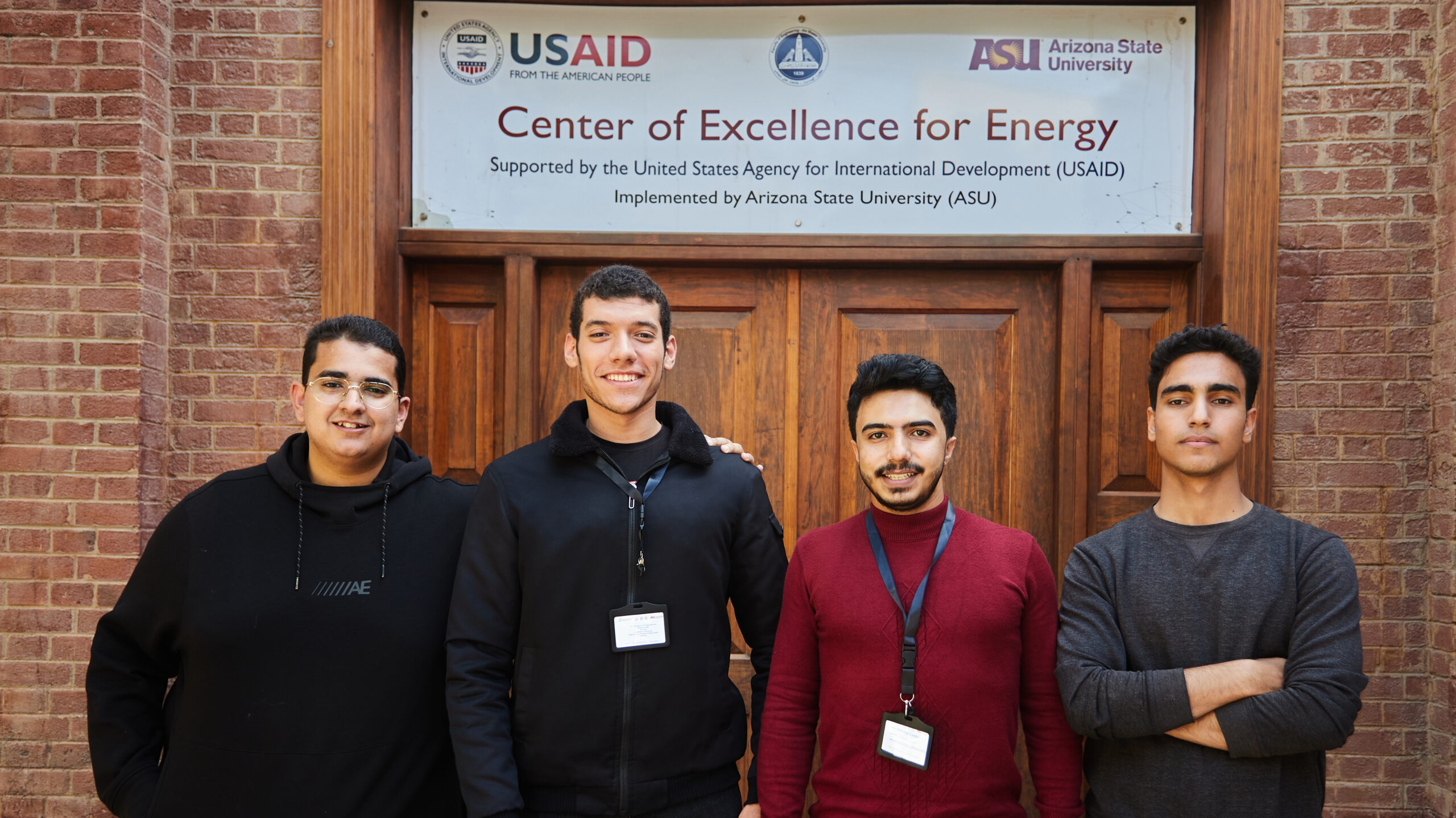 Four male students in front of Center of Excellence for Energy entrance