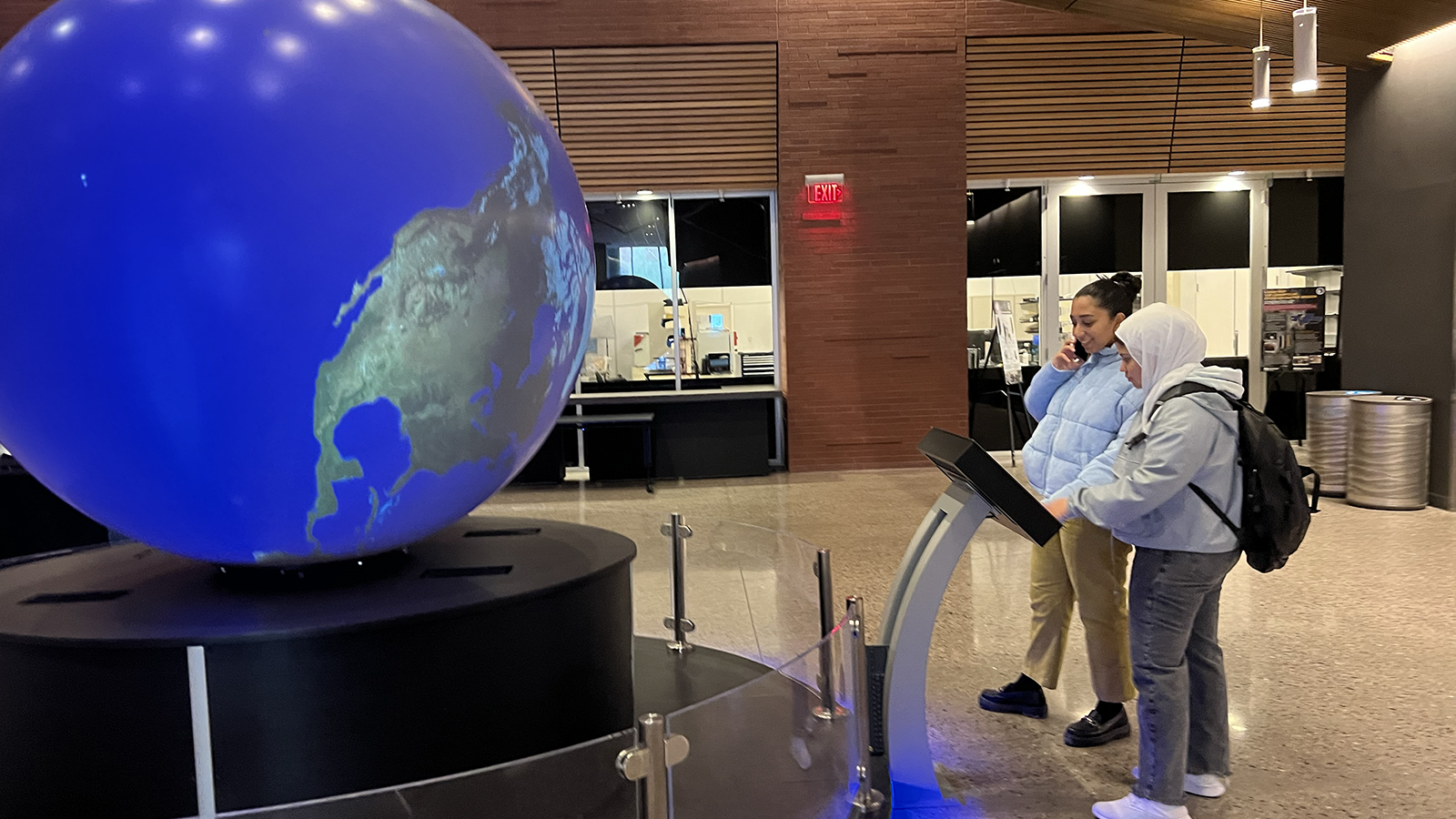 Two female students looking at giant globe
