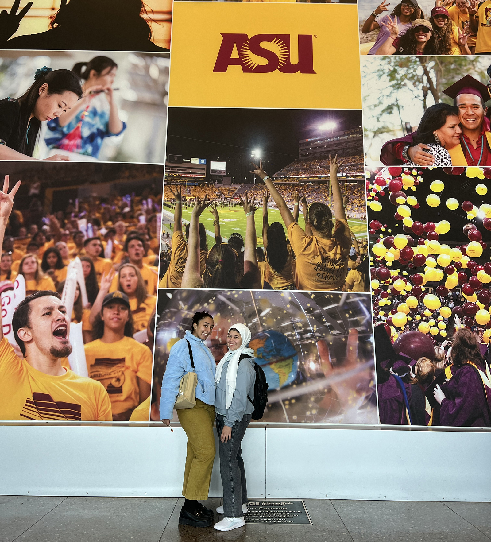 Two exchange students in front of ASU sign